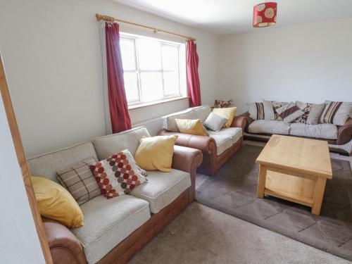 ein Wohnzimmer mit Sofas und einem Tisch in der Unterkunft Barbara's Cottage in Terranea
