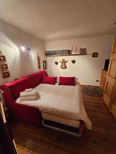 a bedroom with a large bed with red pillows at Maison Courmayeur in Verrand