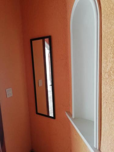 a mirror in a room with an orange wall at Mountain View Lofts Guayabitos in Rincon de Guayabitos