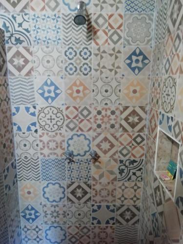 a bathroom with a shower with different colored tiles at Mountain View Lofts Guayabitos in Rincon de Guayabitos
