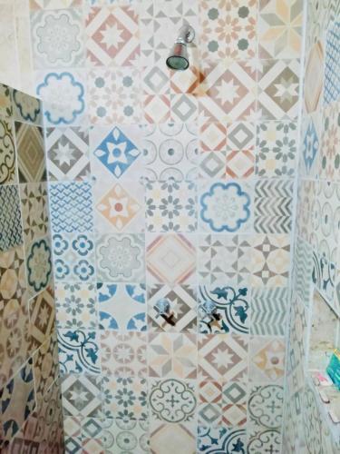 a bathroom with a tile wall with a shower at Mountain View Lofts Guayabitos in Rincon de Guayabitos