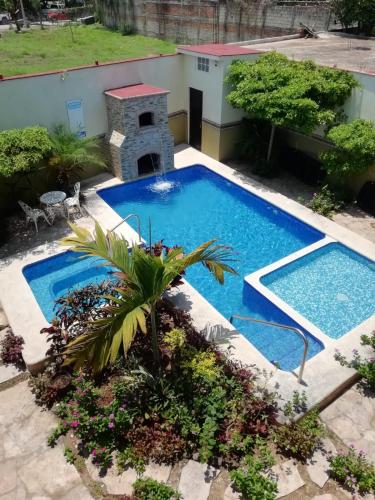 a small swimming pool with a palm tree in a yard at Mountain View Lofts Guayabitos in Rincon de Guayabitos
