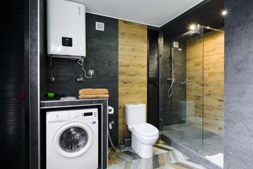 a bathroom with a washing machine and a toilet at Apartments Center2- Олімпійська - ЖК Manhattan City KПІ -Лесі Українки бульвар in Kyiv