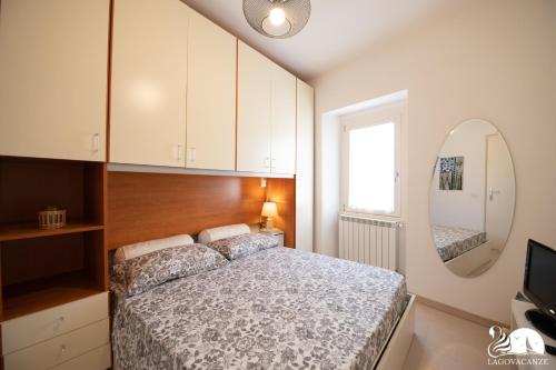 - une chambre avec un lit et un miroir dans l'établissement La Colomba, à San Felice del Benaco