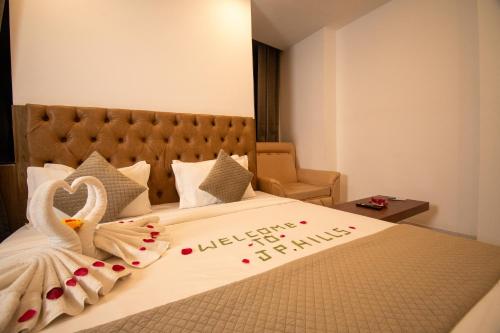 a bedroom with a bed with a swan decoration on it at Hotel JP Hills Rishikesh in Rishīkesh