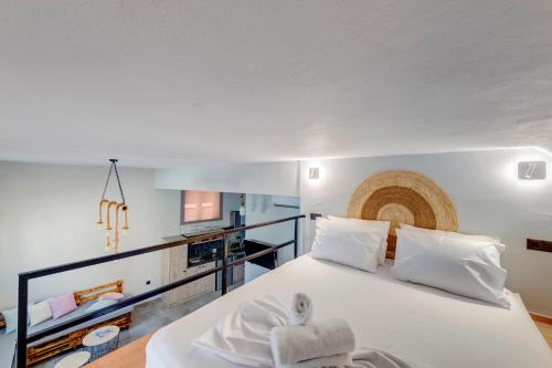 a bedroom with a large white bed with white pillows at LUNA & TERRA APARTMENTS SYROS in Ermoupoli