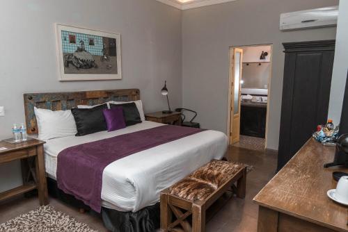 um quarto com uma cama grande num quarto em Casa Brunella - Hotel Boutique Querétaro em Querétaro