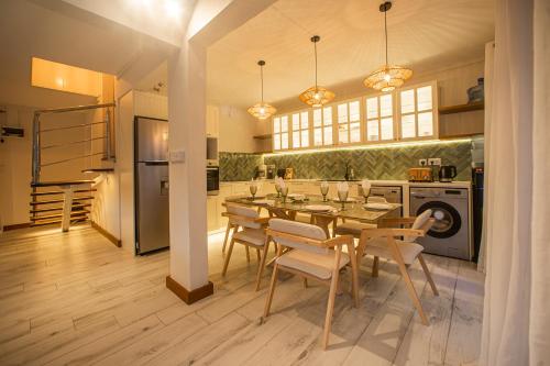 a dining room with a table and chairs in a kitchen at Between 2 waters Villa, free rental car offered. in Tamarin