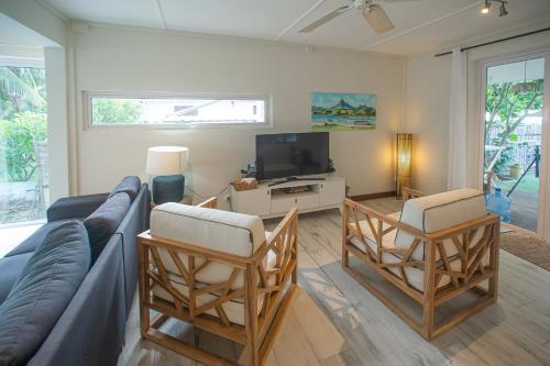 a living room with a couch and chairs and a tv at Between 2 waters Villa, free rental car offered. in Tamarin