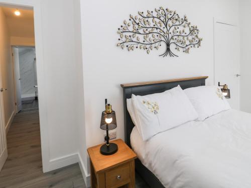 1 dormitorio con 1 cama con un árbol en la pared en Jasmine Villa en Llandudno