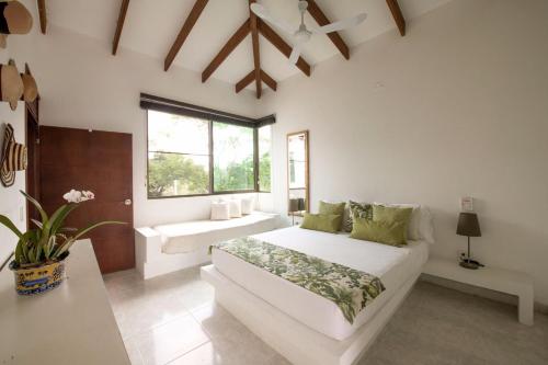 a white bedroom with a bed and a window at Finca San Pedro in La Mesa