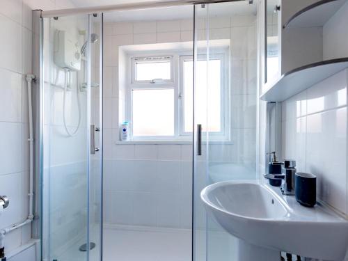 a bathroom with a glass shower and a sink at Pass the Keys Cosy Cottage with Fireplace in Bridgwater