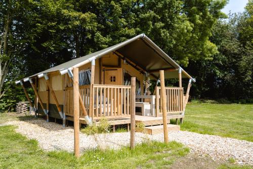 a large wooden hut in a field of grass at Recreatiepark de Markplas in Opheusden