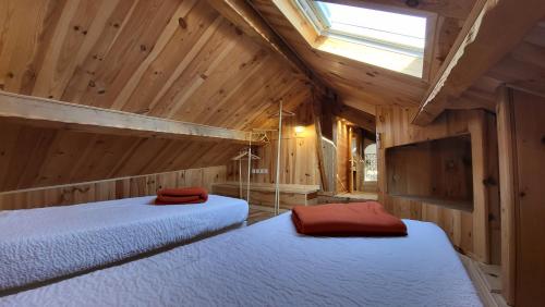 2 camas en una habitación con paredes de madera y ventana en Entre ciel et mer dans la Citadelle, en Calvi