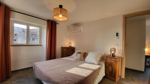 een slaapkamer met een bed en een raam bij Entre ciel et mer dans la Citadelle in Calvi