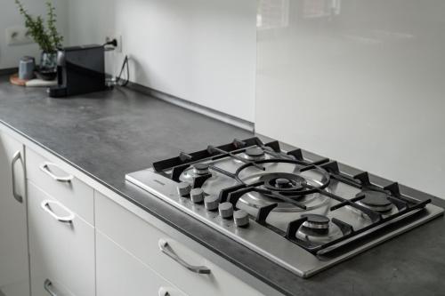 a stove top oven sitting on top of a kitchen counter at Vakantiewoning 't Hovenshuis in Kinrooi