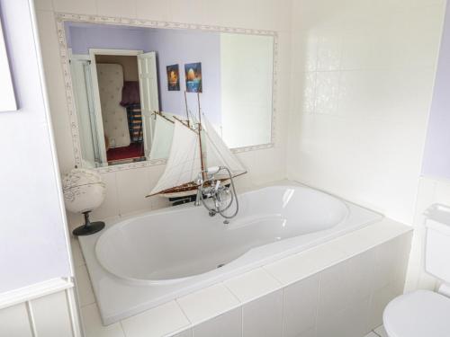 a white bath tub in a bathroom with a boat on it at The White House in Drumshanbo