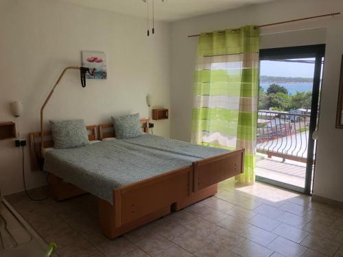 a bedroom with a bed and a sliding glass door at DeltaS Appartmani in Banjol