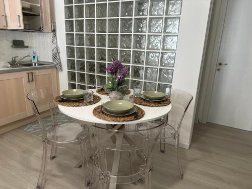 a kitchen with a table with four chairs and flowers at Monolocale Portoverde Beach in Misano Adriatico