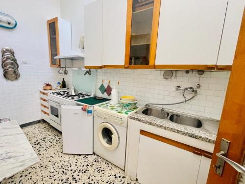 a small kitchen with a sink and a washing machine at Casa Racchia in Porto Santo Stefano
