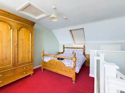 a bedroom with a bed and a wooden cabinet at Holiday Apartment Iris in Waterford
