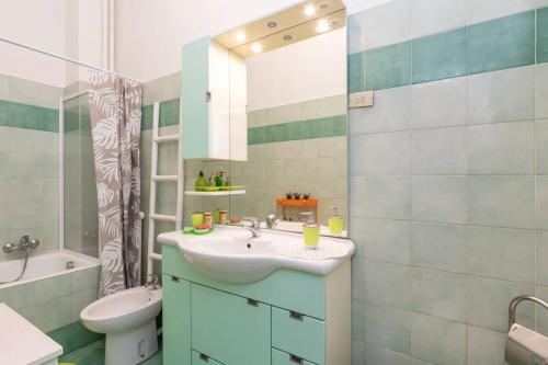 a bathroom with a sink and a toilet and a mirror at [IHost Apartment] - Bassini 46 in Milan