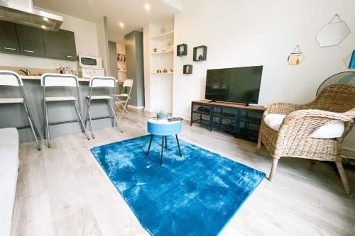 ein Wohnzimmer mit einem TV und einem blauen Teppich in der Unterkunft #D5 Blue Lagoon Caserne de Bonne in Grenoble