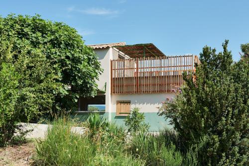 ein Haus mit einem Zaun an der Seite in der Unterkunft Domaine La Ferme HI bride in Villelaure