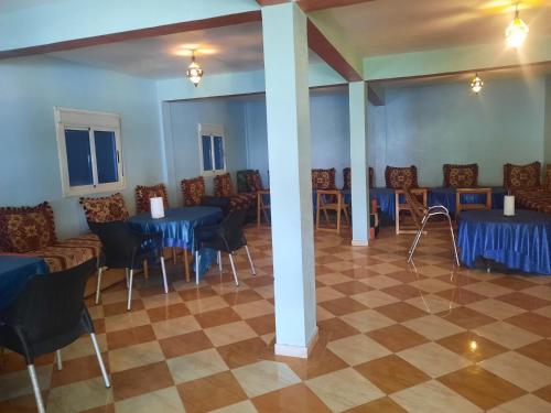 - une salle à manger avec des tables et des chaises bleues dans l'établissement Auberge l'avenir, à Imilchil