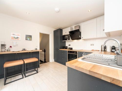 uma cozinha com armários brancos e uma bancada em Pass the Keys Elegant Modern 2 Bed Flat Near Greenwich Park em Londres