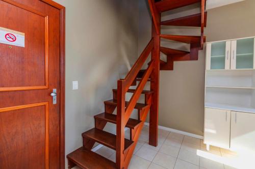 a wooden staircase in a room next to a door at Hotel Morada Del Este in Canoas