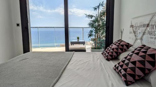 een slaapkamer met een bed en uitzicht op de oceaan bij SUNSET WAVES sea view apartments in Benidorm