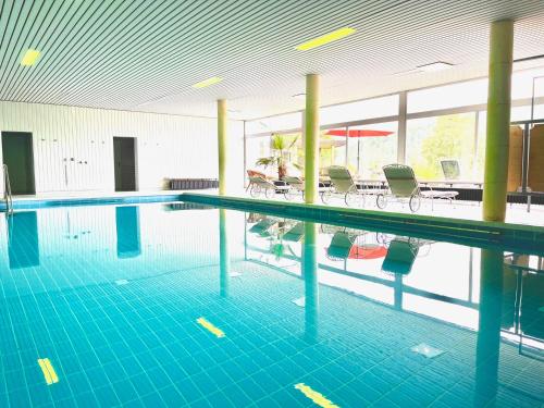 - une grande piscine avec des carreaux bleus dans un bâtiment dans l'établissement Hotel Sonnenberg Garni, à Hinterzarten