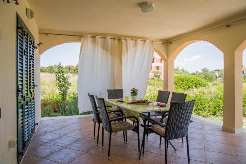 une salle à manger avec une table et des chaises sur une terrasse dans l'établissement Holiday home Nora, à Drače