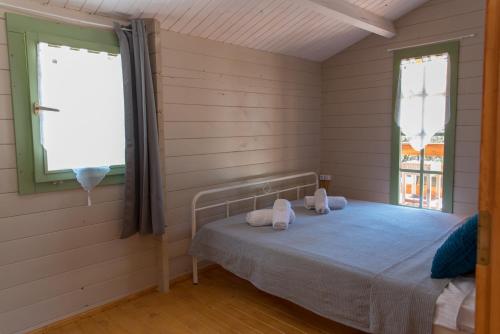 1 dormitorio con 1 cama en una habitación con ventana en metaxaki cottage, en Mikros Gialos