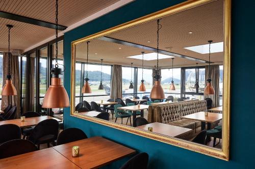 un miroir dans un restaurant avec des tables et des chaises dans l'établissement AMANTE, à Belp