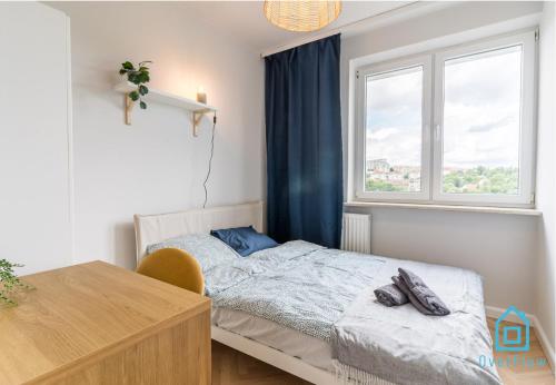 a bedroom with a bed and a desk and a window at Bigly Room in Gdańsk