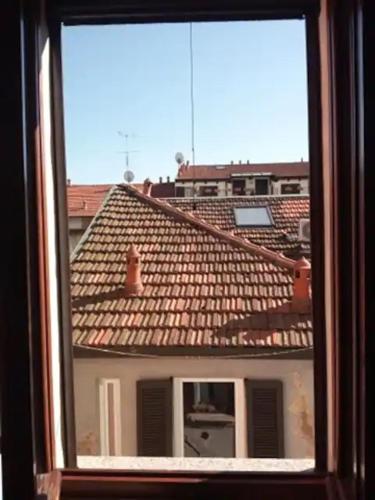 a view of a roof of a building from a window at Governo Provvisorio House in Milan