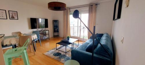 a living room with a couch and a table at Spacious 67 m nest near the Stade de France in Saint-Denis