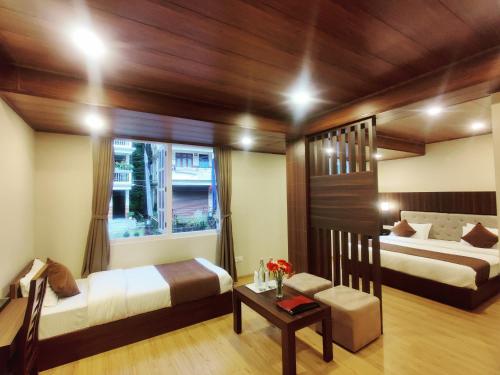 1 dormitorio con 2 camas y ventana en Keswani Group Tashi Heritage Hotel & Resort en Gangtok