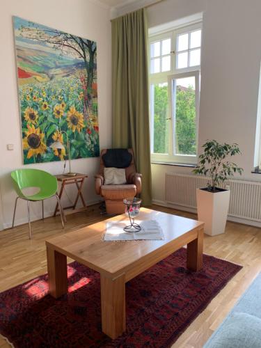 a living room with a table and a painting at Remedium Appartements in Vlotho