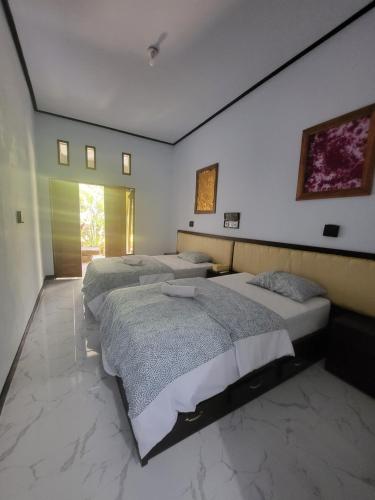 a bedroom with two beds and a wall at Exotic Backpackers in Banyuwedang