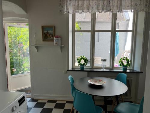 a kitchen with a table and chairs and a window at Villa Brigitta, havsnära boende mittemot Klostret i Ystad centrum in Ystad