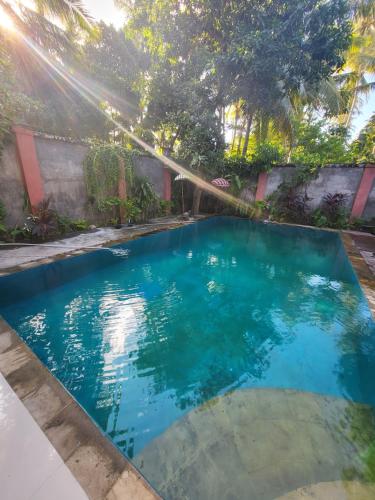 a swimming pool in a backyard with blue water at Exotic Backpackers in Banyuwedang