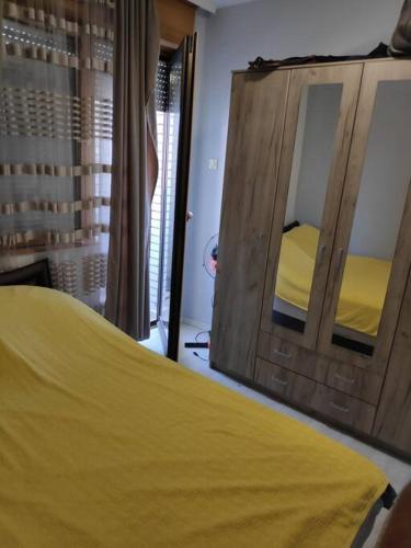 1 dormitorio con cama amarilla y espejo en Nikolaj en Podgorica