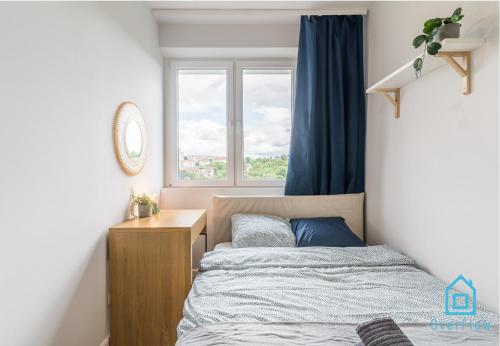 a small bedroom with a bed and a window at Cuddle Room in Gdańsk