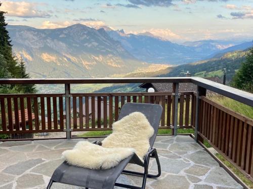 a chair on a balcony with a view of mountains at Chalet Tobeleck - CharmingStay in Flumserberg