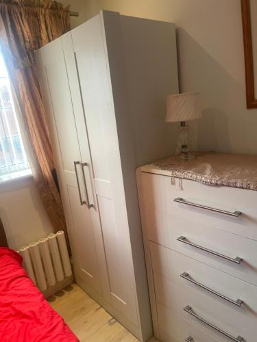 um quarto com um armário branco e uma cama em Jules Homestay Plus em Ocker Hill