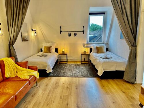 um quarto com duas camas e um sofá e uma janela em Stylish im Altbau, Netflix, Sonos, nahe 3M und Vorwerk em Wuppertal
