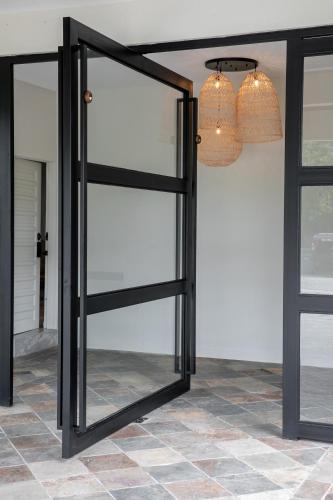 a glass door in a room with a chandelier at Kontor Mansion - 3 mins to Teluk Chempedak Beach & Private Pool in Kuantan